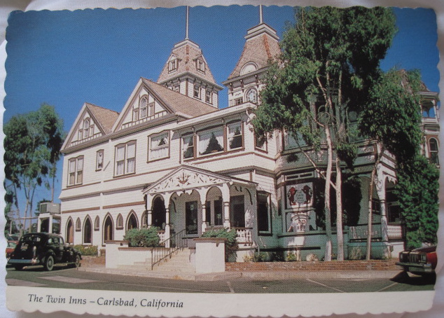 Victorian-style building with towers and arches, labeled The Twin Inns, Carlsbad, California.