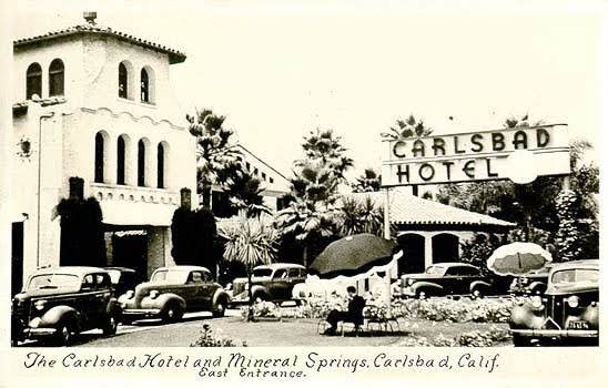 Vintage photo of Carlsbad Hotel entrance with parked cars.