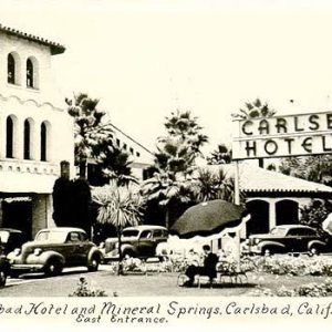 Vintage photo of Carlsbad Hotel entrance with parked cars.