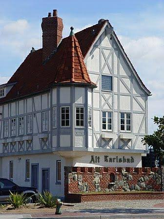 Traditional half-timbered house with steep roof and chimney.