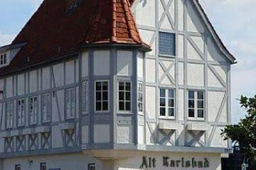 Traditional half-timbered house with steep roof and chimney.