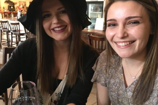 a woman sitting at a table and smiling at the camera