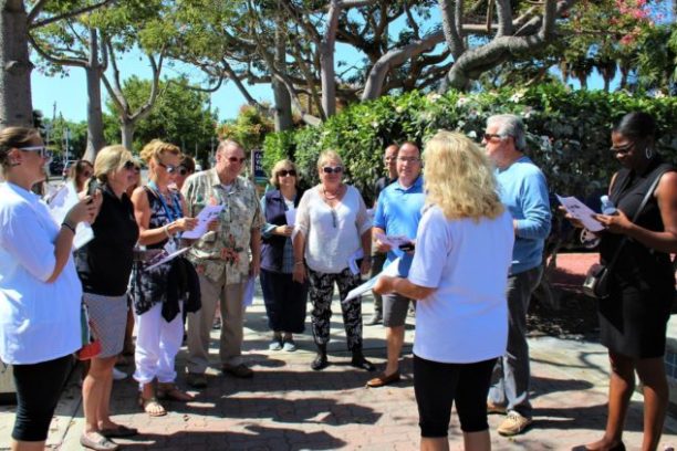 a group of people standing on a sidewalk