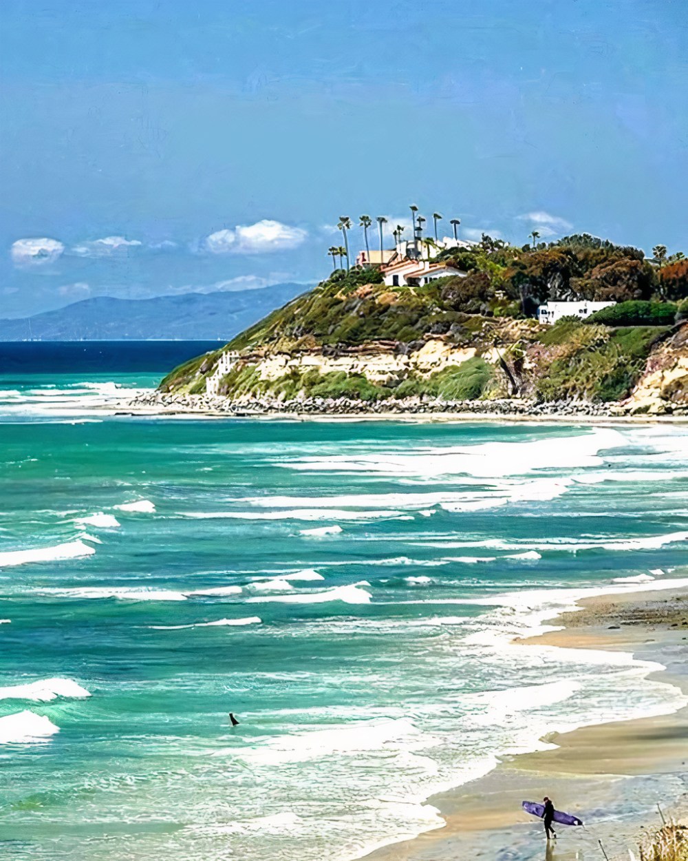 a group of people walking across a beach next to the ocean