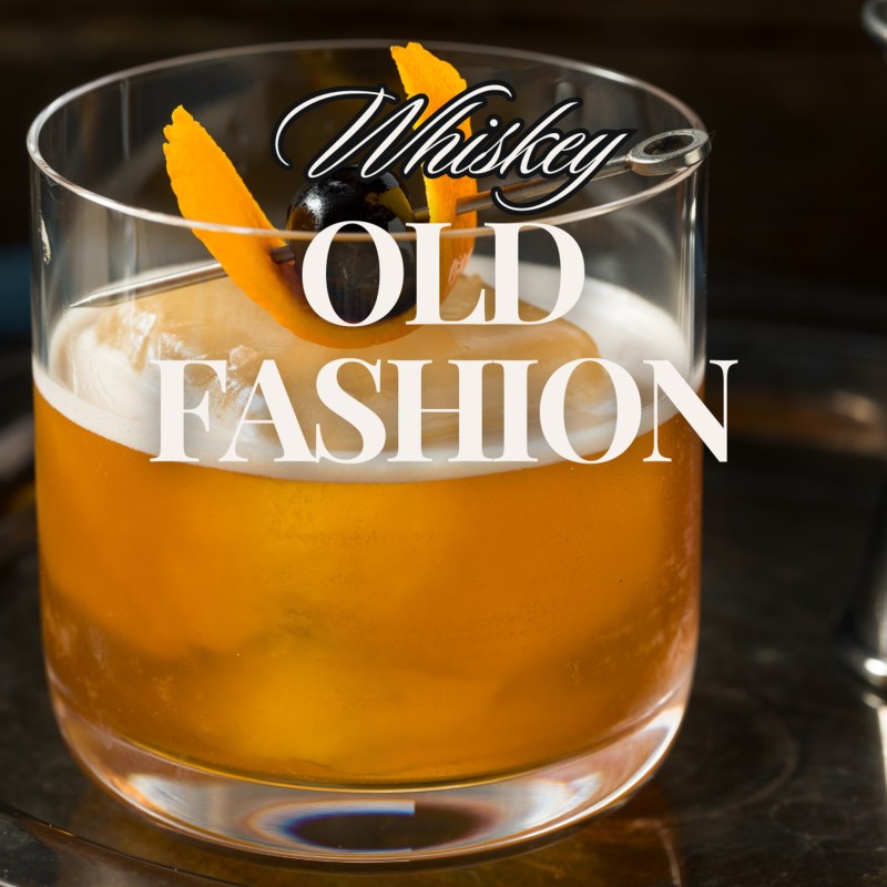 A whiskey old fashioned cocktail with an orange peel and cherry garnish.