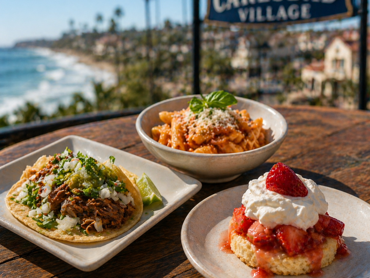 Three dishes on a table overlooking a coastal view with a 'Carlsbad Village' sign.