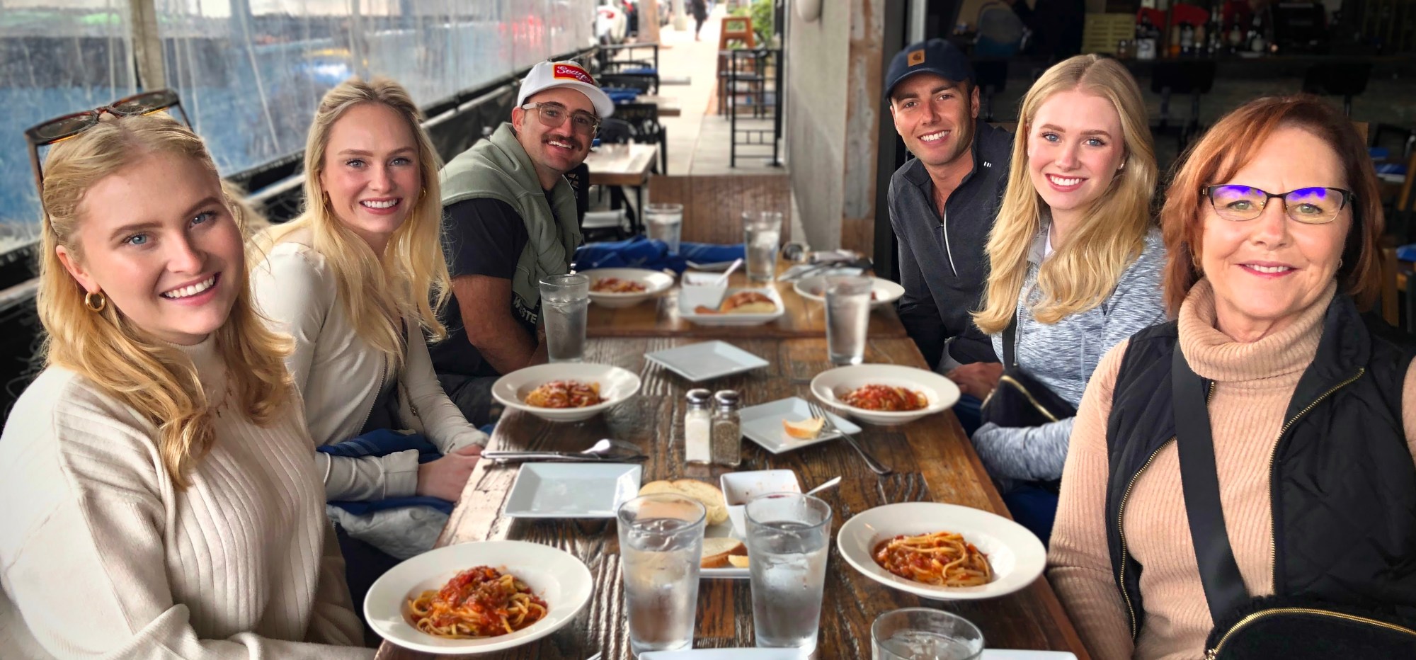 a group of people sitting at a table with a plate of food