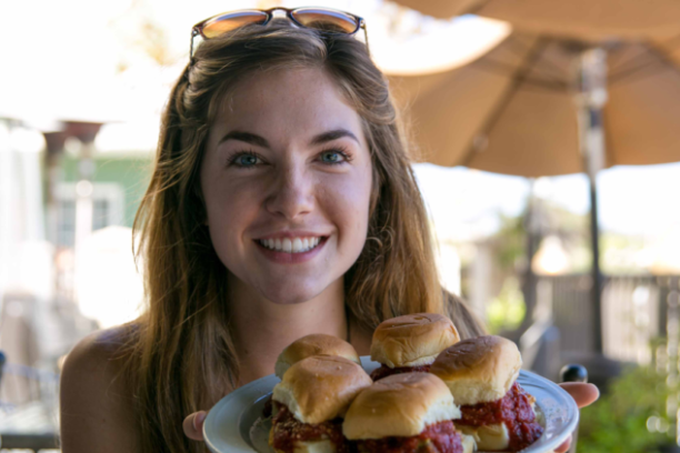 a woman sitting at a table with a plate of food