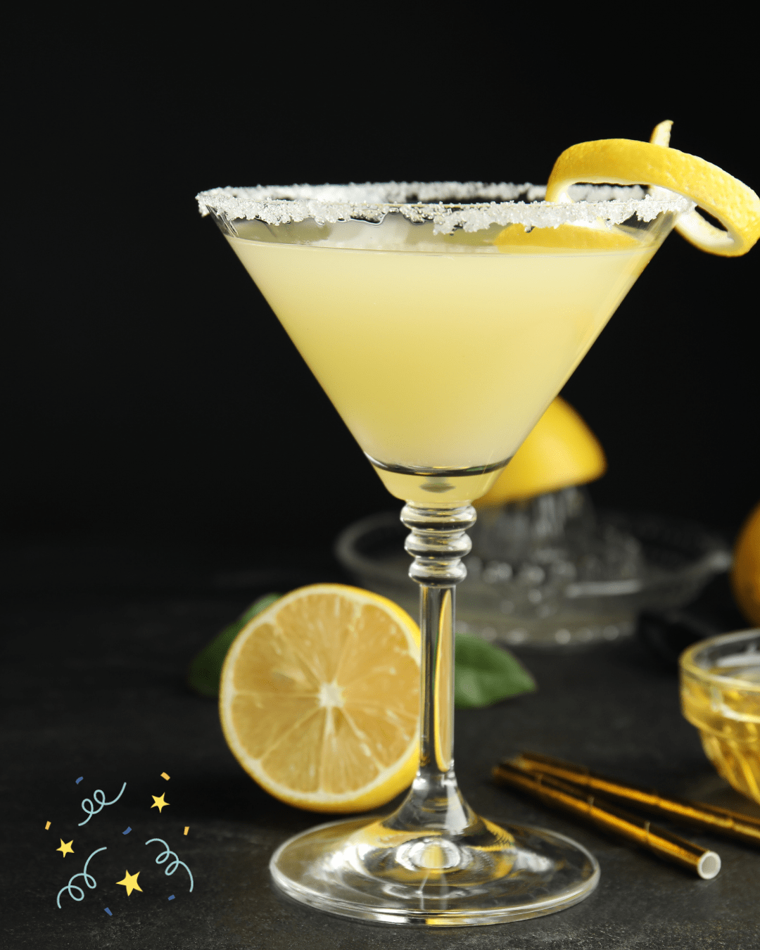 Lemon cocktail in a glass with sugared rim and lemon twist, surrounded by sliced lemons.