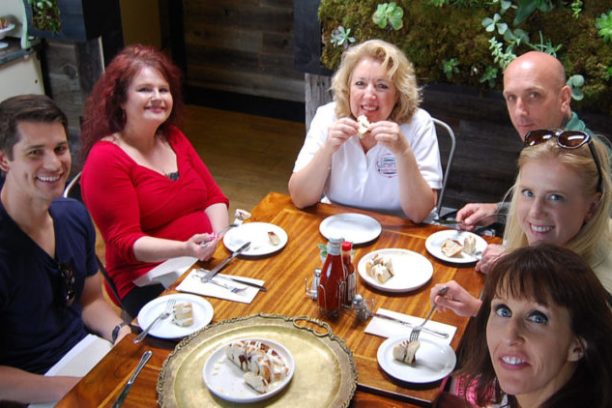 a group of people sitting at a table eating food