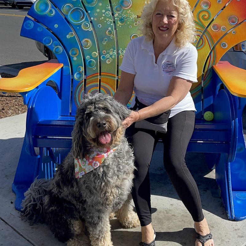 a woman holding a dog posing for the camera