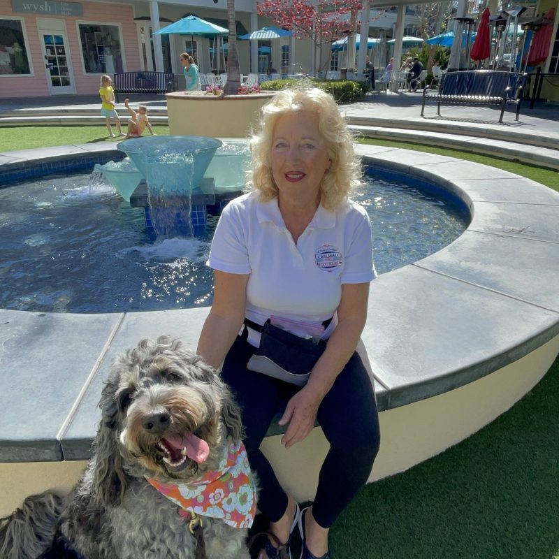 a person holding a dog on a leash in front of a building