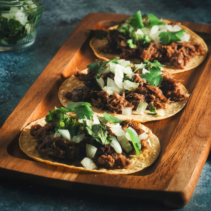 a slice of pizza sitting on top of a wooden cutting board