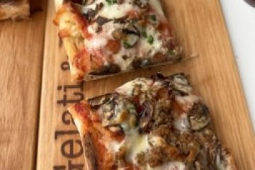 a slice of pizza sitting on top of a wooden cutting board