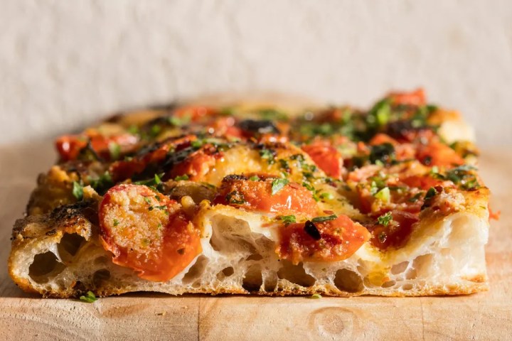 a slice of pizza sitting on top of a wooden cutting board