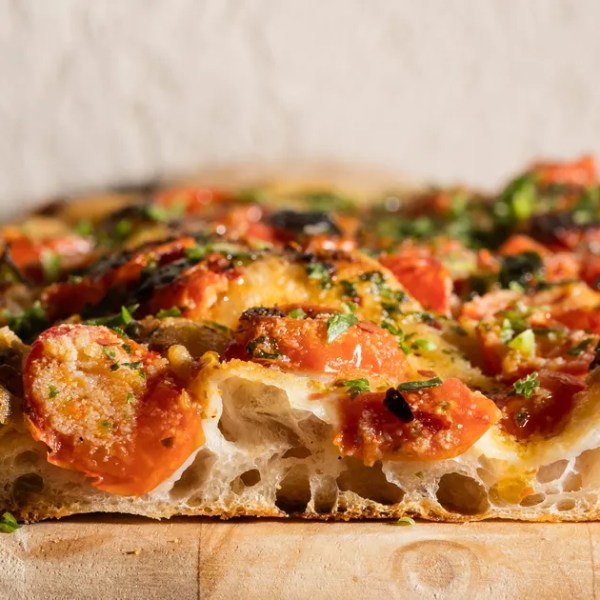 a slice of pizza sitting on top of a wooden cutting board