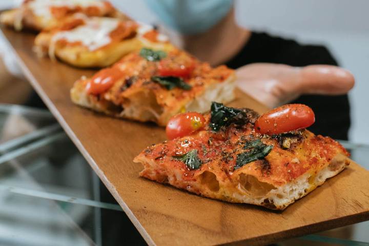 a slice of pizza sitting on top of a wooden cutting board