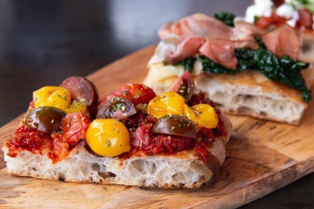 a slice of pizza sitting on top of a wooden cutting board