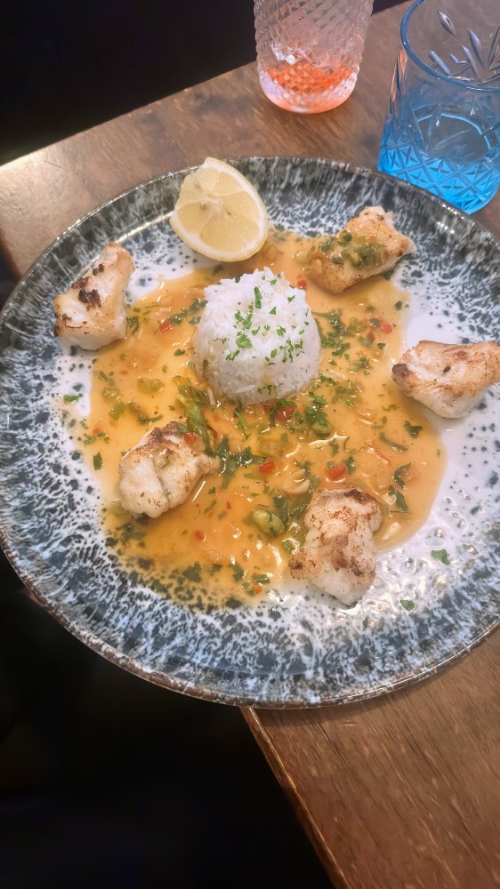 Three sausages on sauerkraut with mashed potatoes, side dishes on table.