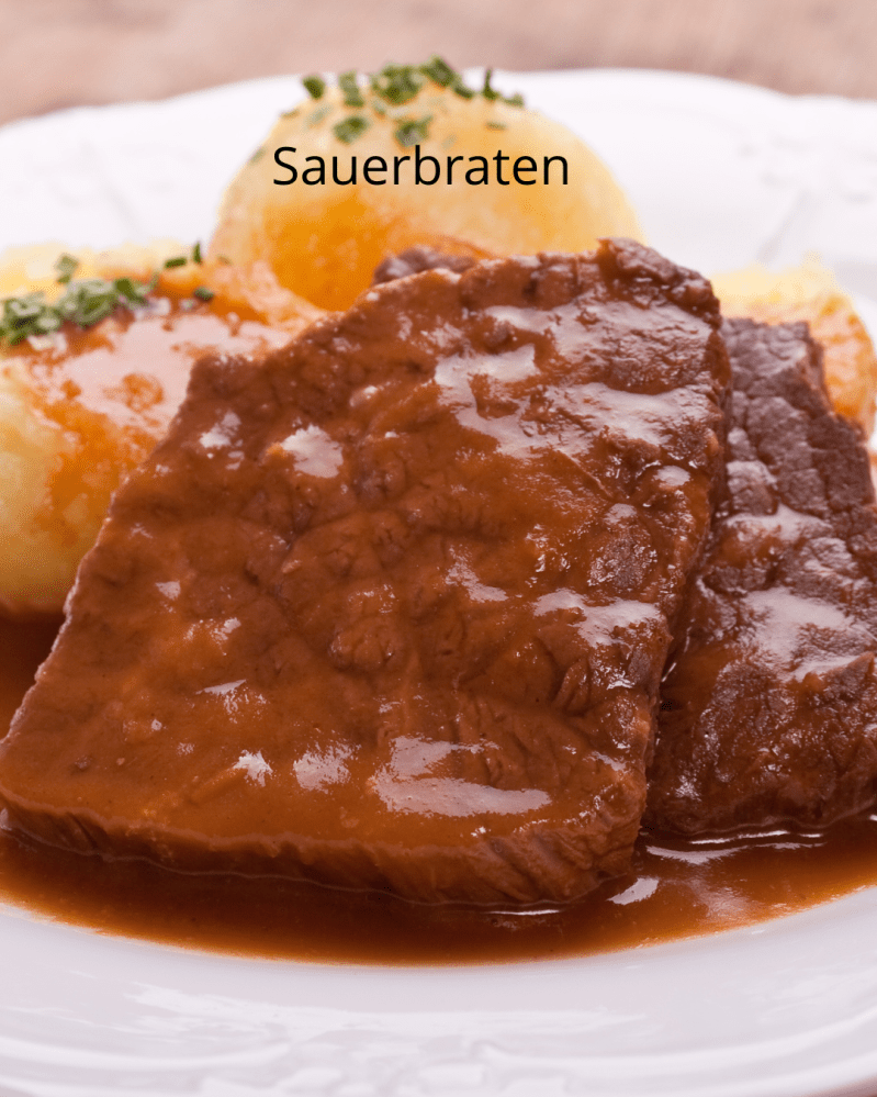 Slices of sauerbraten with gravy, garnished with herbs and served with dumplings.