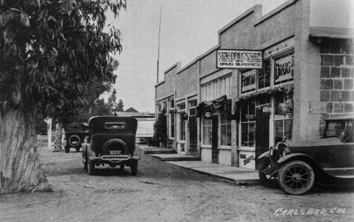Vintage cars parked on a street by old storefronts, Carlsbad, CA.