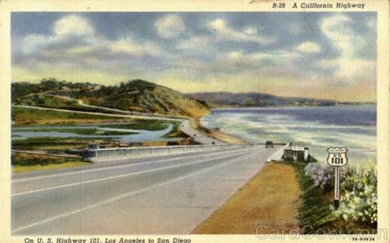 Vintage postcard of Highway 101 along the coast with cars and hills in the background.