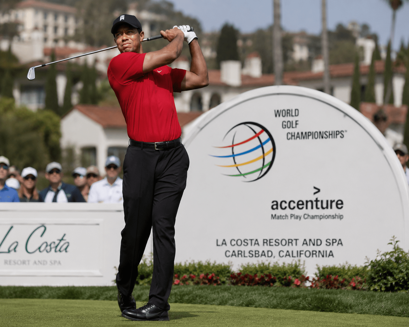 Golfer in red shirt swings club at World Golf Championships in California.