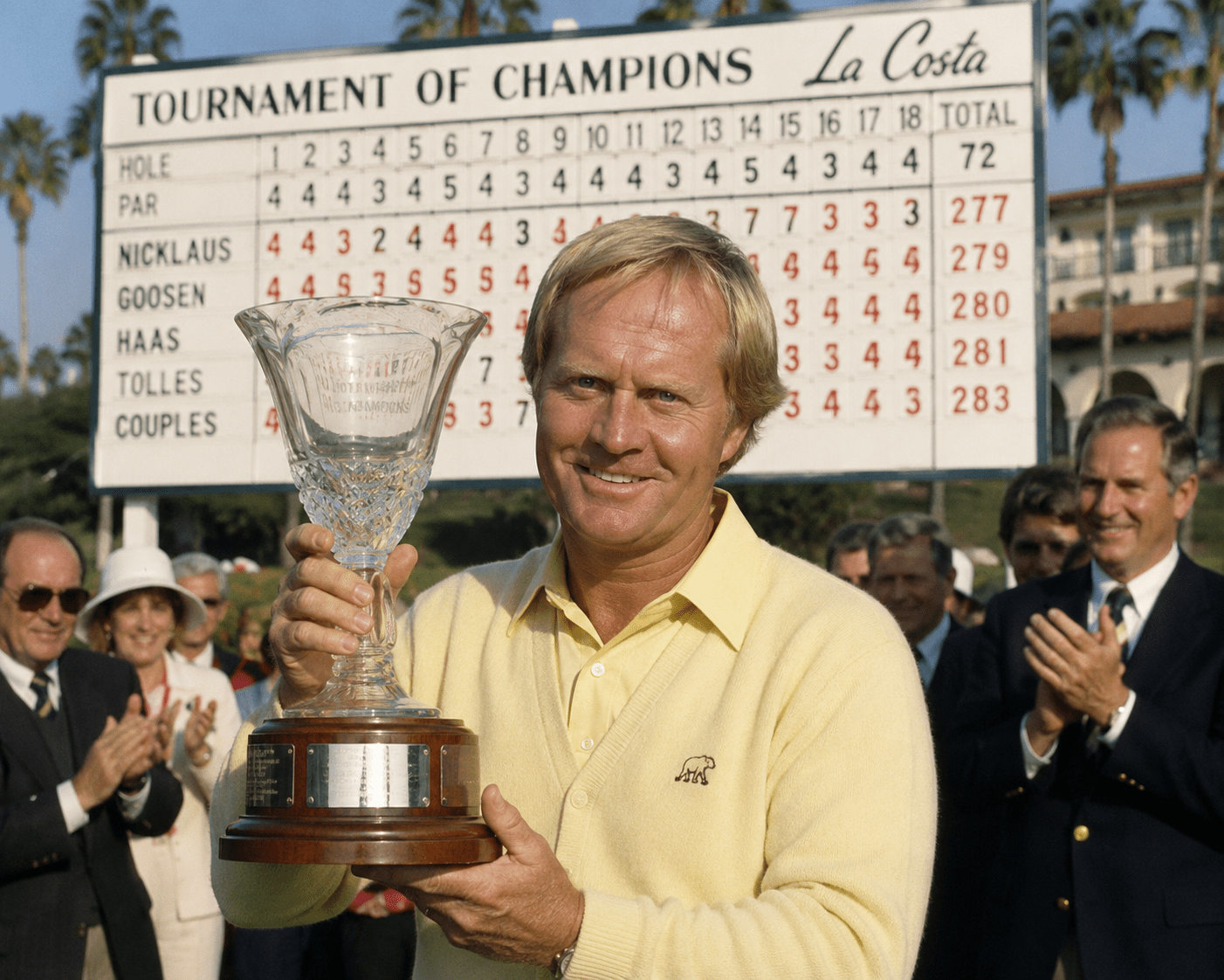 Golfer holding trophy in front of leaderboard at Tournament of Champions.