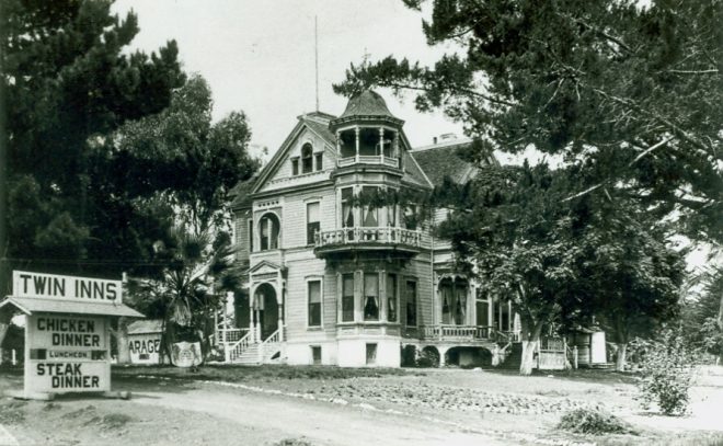 Historic mansion surrounded by trees with a sign advertising chicken and steak dinners.