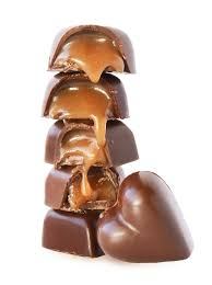 Stacked caramel-filled chocolates with one heart-shaped piece.