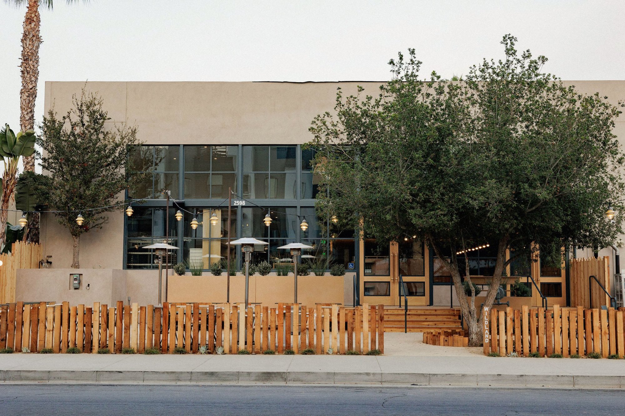 Modern building with a wooden fence and outdoor seating area.